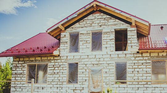 Bauen und Umziehen – Baustelle mit Haus